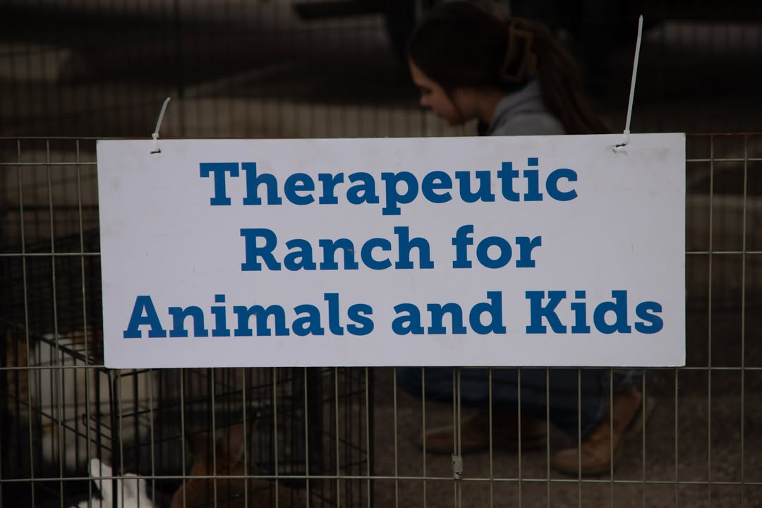 Therapeutic Ranch for Animals and Kids sign on a pen with animals