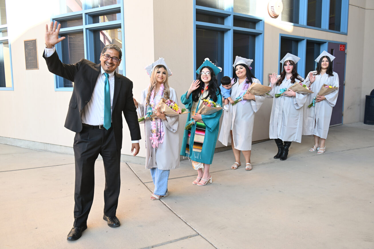 TAP Principal Israel Macias and the five graduates smile and wave