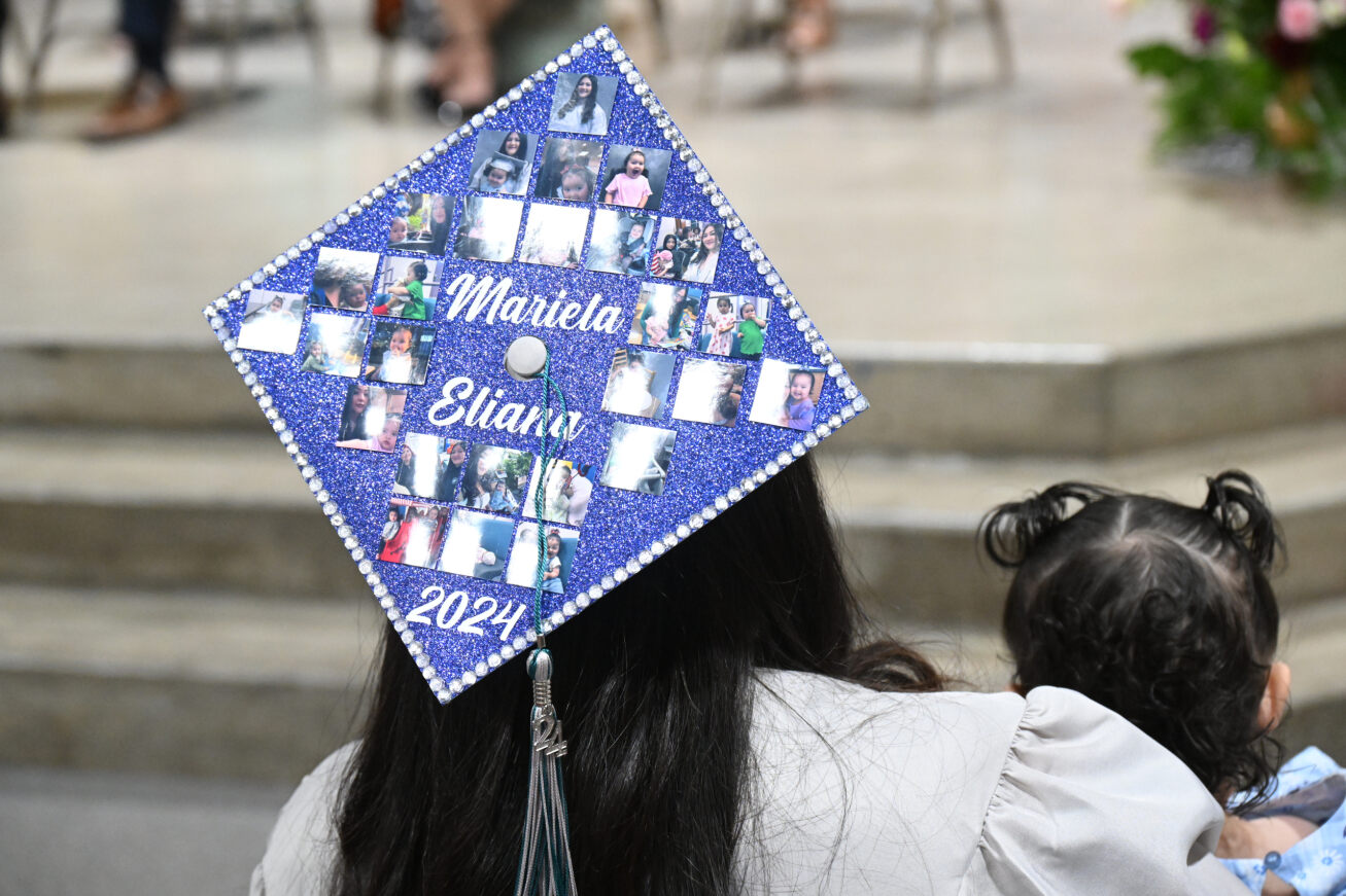 A TAP student's graduation cap reading Mariela and Eliana 2024 with photos of the mom and daughter on it